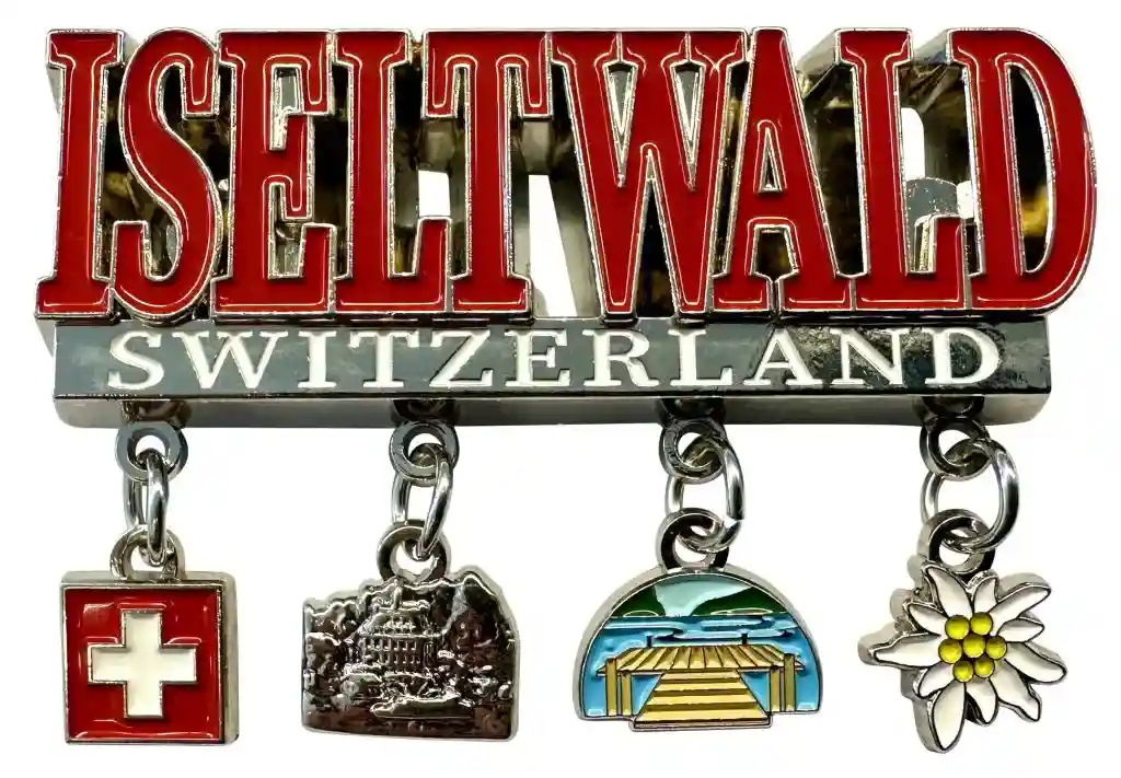 Eine Anstecknadel von grosshandel Schweiz mit der Aufschrift Iseltwald Switzerland und vier baumelnden Anhängern darunter.